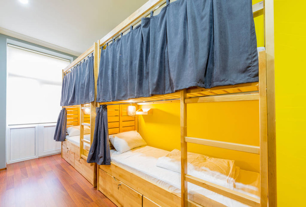Hostel dormitorium łóżka rozmieszczone w pokoju - Zdjęcie, obraz