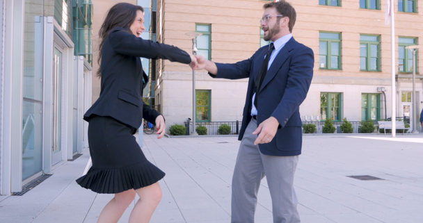 Dos socios de negocios de cinco y bailando fuera del edificio de oficinas en 4k
 - Metraje, vídeo