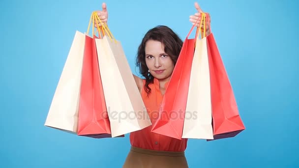 Ευτυχισμένη νεαρή γυναίκα κουβαλάει τσάντες για ψώνια - Πλάνα, βίντεο