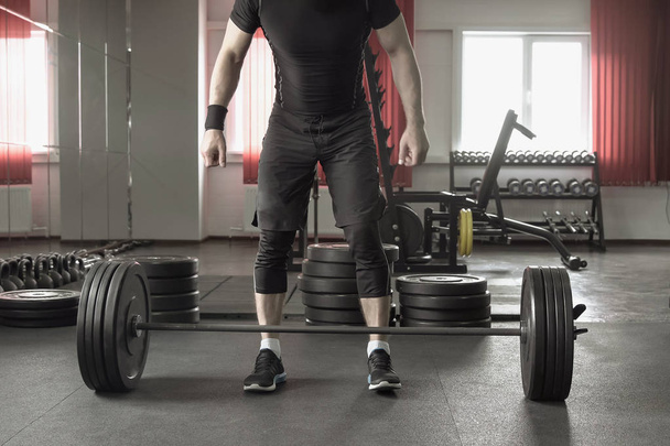 close up of man doing deadlift exercise in gym. - Foto, imagen