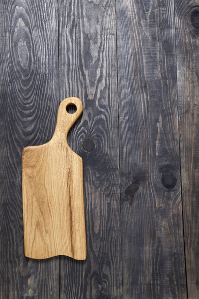 Tabla de cortar sobre una superficie de madera
 - Foto, Imagen