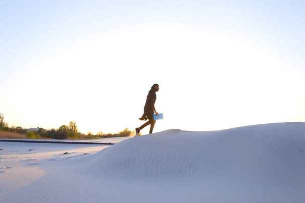 Korkeus mies muslimi päälle hiekkadyynin yli valkoista hiekkaa
 - Valokuva, kuva