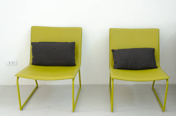 Cadeiras de ferro verde e almofadas em uma cadeira preta
. - Foto, Imagem