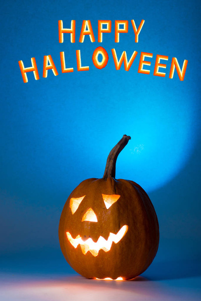 Halloween pumpkin, silhouette of funny face on blue background. - Zdjęcie, obraz