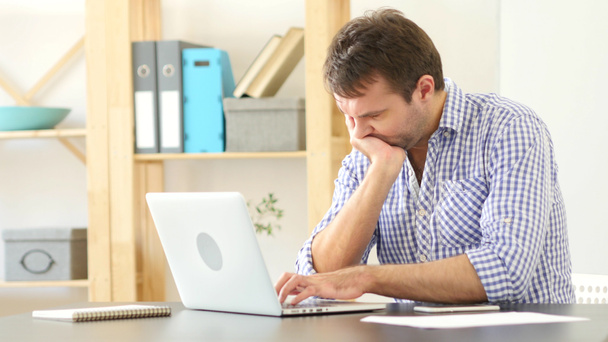 Αναστατωμένος και απογοητευμένος ο άνθρωπος σκέφτεται και λειτουργεί σε φορητό υπολογιστή - Φωτογραφία, εικόνα