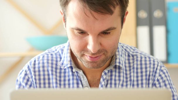 Hombre trabajando en el ordenador portátil, Vista frontal de cerca
 - Foto, imagen