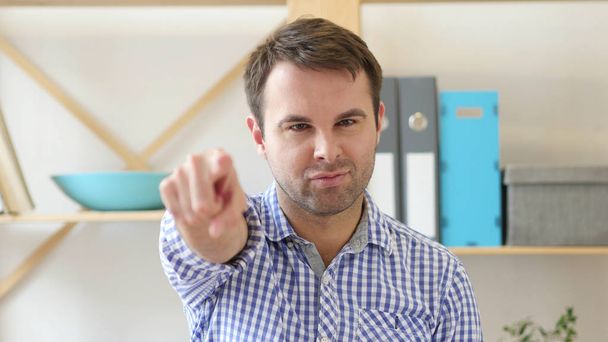 Man Pointing at Camera Sitting in Office - Foto, immagini