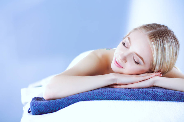 Young woman lying on a massage table,relaxing with eyes closed. Woman. Spa salon - Фото, зображення
