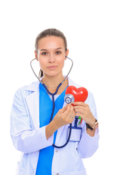 Positive female doctor standing with stethoscope and red heart symbol isolated. Woman doctor - Foto, immagini