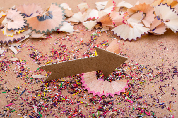 Arrow cut out of paper amid pencil shavings - Photo, Image