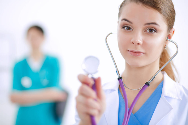 Ελκυστική γυναίκα γιατρός μπροστά από την ιατρική ομάδα - Φωτογραφία, εικόνα