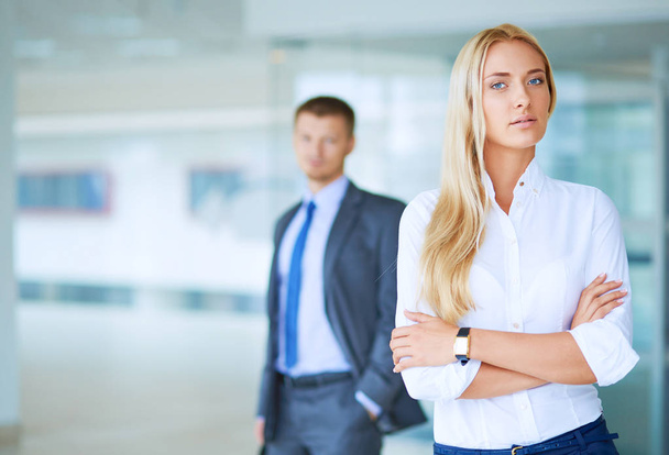 Portrait of young businesswoman in office with colleagues in the background - Photo, image