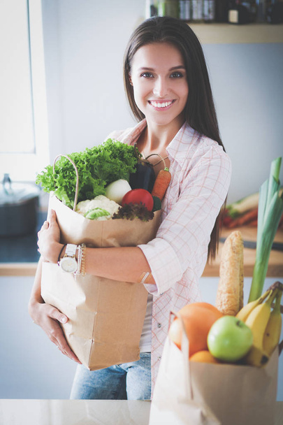 Young woman holding grocery shopping bag with vegetables - Foto, imagen