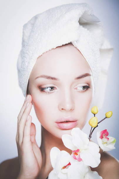 Portrait of beautiful girl touching her face with a towel on her head - Foto, imagen