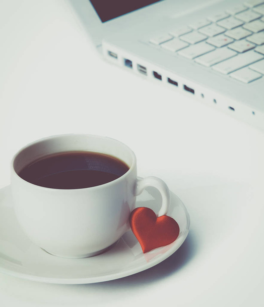 Laptop or notebook with cup of coffee and heart on table - Foto, afbeelding