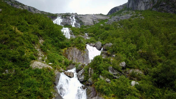 Cachoeira nas montanhas da Noruega em clima chuvoso da vista aérea do drone
 - Filmagem, Vídeo