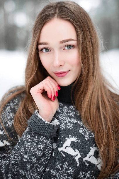 セーターを着て若い美しいブルネットの女性の冬の肖像画。雪の冬の美しさのファッションコンセプト. - 写真・画像