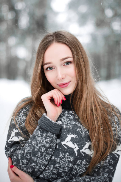 Retrato de invierno de una joven morena hermosa con suéter. Nieva concepto de moda belleza invierno
. - Foto, imagen