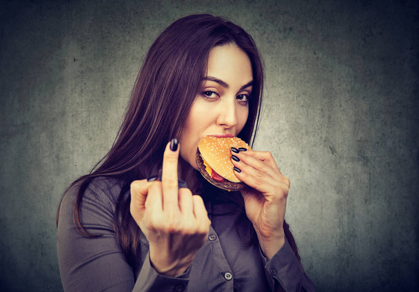 No diet for me! Woman enjoying her tasty cheeseburger   - 写真・画像
