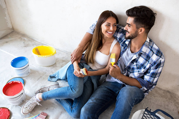 Happy young couple relaxing after painting - Foto, imagen