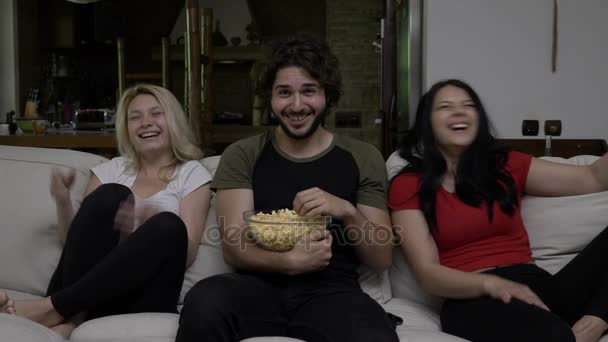 People eat popcorn and watch funny entertainment TV show and find it hilarious - Materiał filmowy, wideo