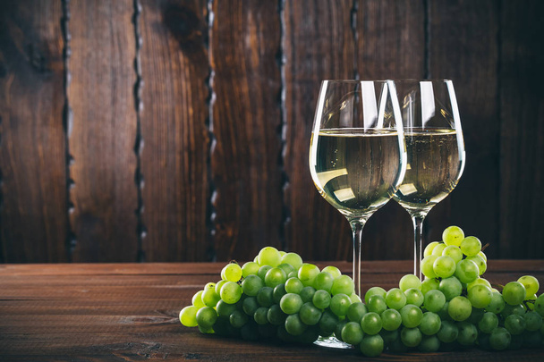 Белое вино в бокалах с виноградом
 - Фото, изображение