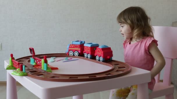tyttö leikkii hänen lelu junat raiteilleen
 - Materiaali, video