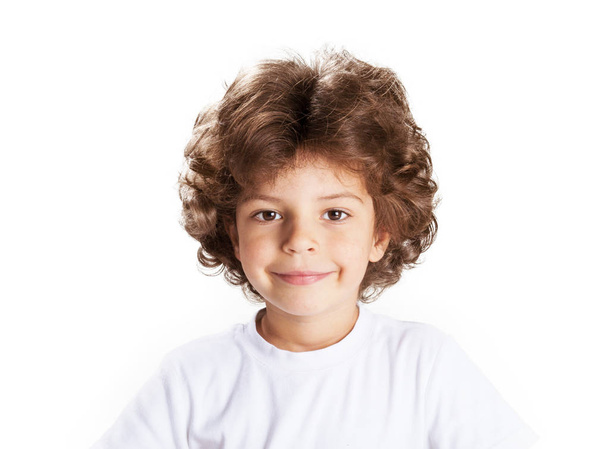 Cute little curly-haired boy with a smile, looking into the camera. White  background. Close-up. - Zdjęcie, obraz