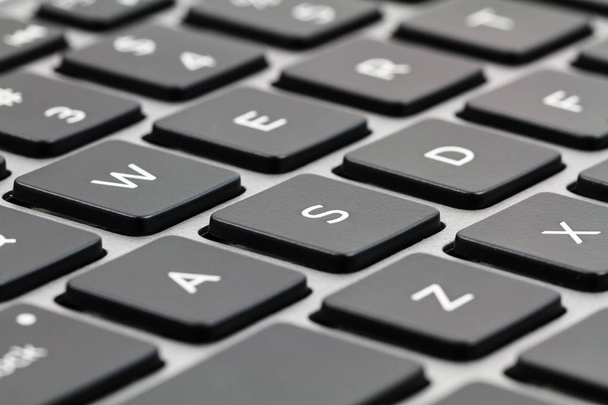 黒鍵と灰色のケースとノート パソコンのキーボード。クローズ アップ - 写真・画像