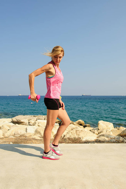 Mladá žena atletická cvičení venku: triceps rozšíření pro horní část těla sílu - Fotografie, Obrázek