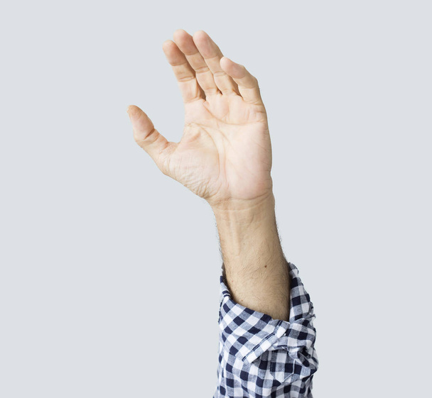 Mão de homem levantada sobre fundo cinza
 - Foto, Imagem