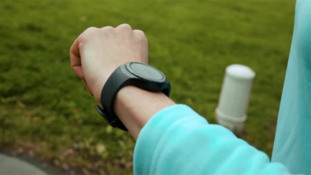 Corredor de mujer usando rastreador de fitness de reloj inteligente
 - Metraje, vídeo
