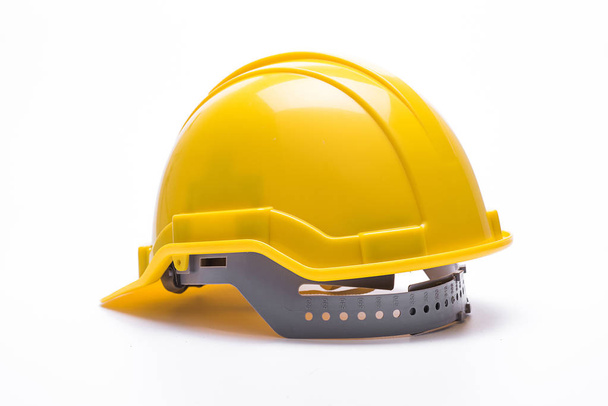 Желтый шлем безопасности изолирован на белом фоне. - Фото, изображение