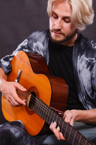 Blonde man playing acoustic guitar - Fotó, kép