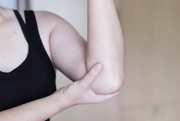 Ellbogenschmerzen. Frauen halten Hand auf seinen schmerzenden Ellbogen, Sport körperliche Verletzungen beim Training. - Foto, Bild
