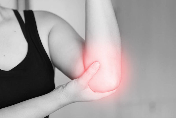 dolor de codo. Las mujeres toman la mano en su codo doloroso, lesiones físicas deportivas cuando hacen ejercicio
. - Foto, imagen