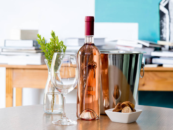 Винний келих і пляшка вина на столі
 - Фото, зображення