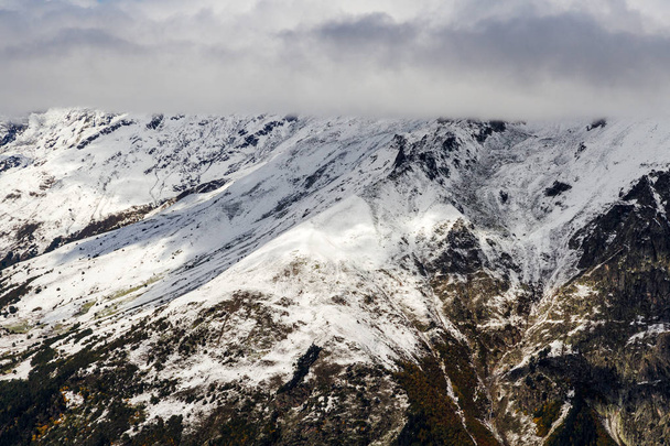 Kaukasus Berge durch den Winter mit Schnee bedeckt mit bewölktem Himmel über ihnen. - Foto, Bild