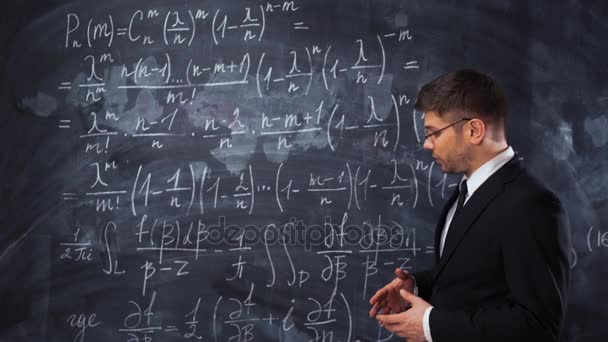 Mladý muž, učitel nebo student, vysvětluje rozhodnutí tvrdé matematické rovnice - Záběry, video
