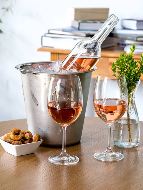 Glas wijn en een fles wijn op tafel - Foto, afbeelding