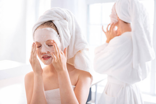 Relaxed teenager doing face mask - Foto, afbeelding