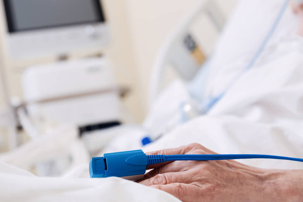 Frágil mujer enferma usando dispositivo que monitorea su pulso
 - Foto, imagen