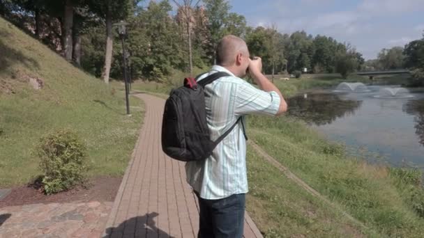 Man neemt foto's op fotocamera in park - Video