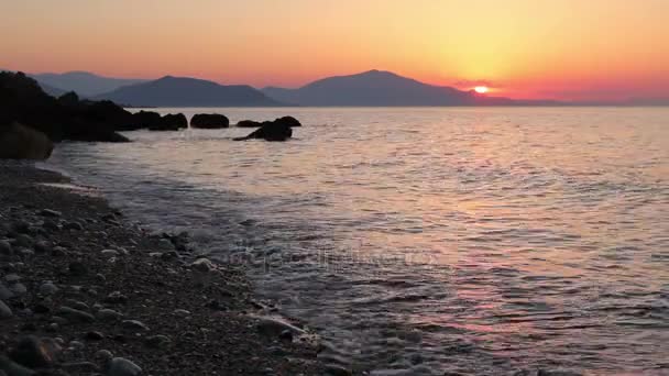 Silhouetted πλάνο της όμορφο ηλιοβασίλεμα στην παραλία - Πλάνα, βίντεο