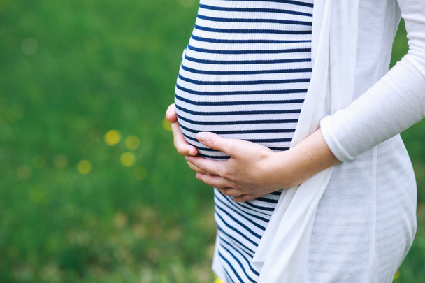 Donna incinta in posa nel parco
 - Foto, immagini