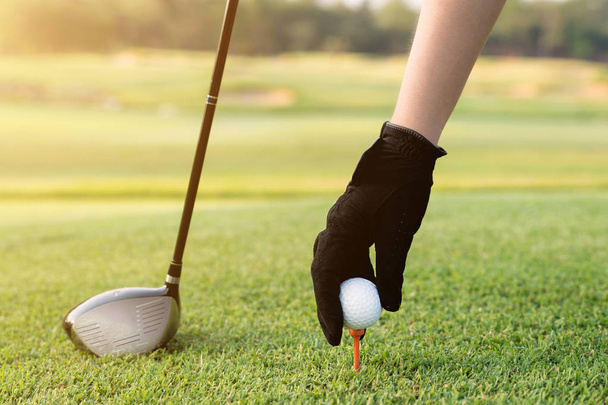 El bir tee golf topu ile yerleştirme. Elini tut tee golf topuyla  - Fotoğraf, Görsel