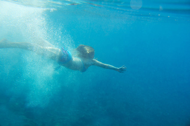 Woman swimming underwater - Foto, afbeelding