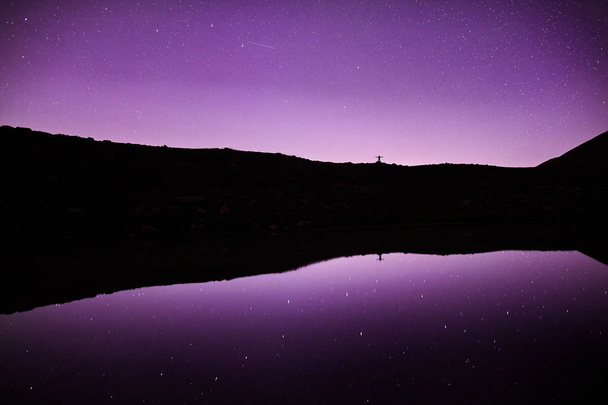 Adam yıldızlı gece gökyüzüne dağlarda - Fotoğraf, Görsel