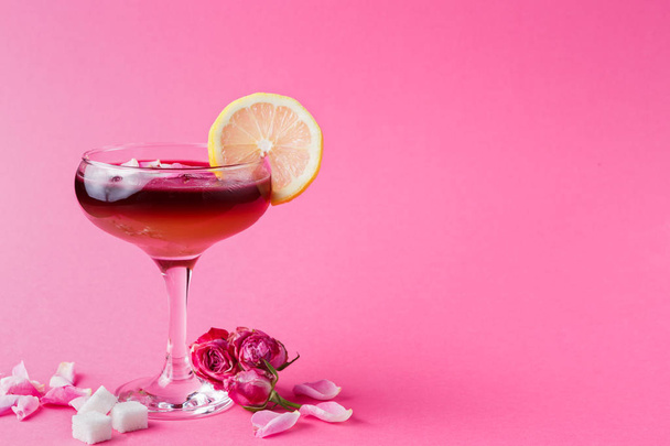 Τριαντάφυλλο κοκτέιλ στο ποτήρι σαμπάνιας σε ροζ φόντο - Φωτογραφία, εικόνα