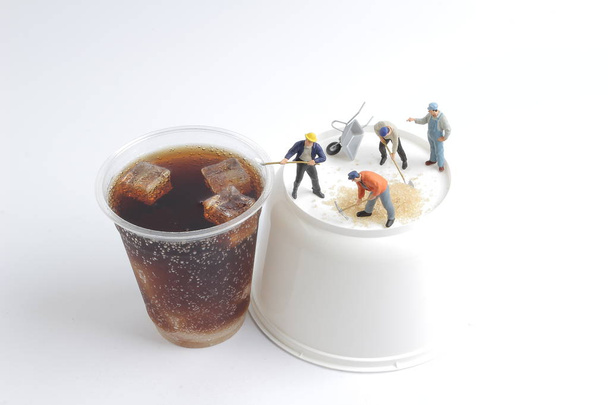 ソフトド リンクのカップとミニ人労働者 - 写真・画像